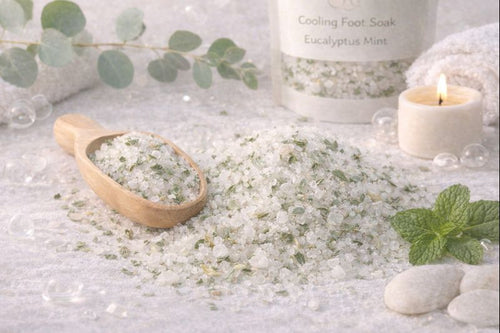 Bath salts with a wooden scoop, eucalyptus leaves, and a candle on a light background