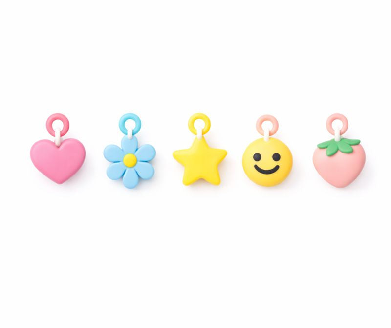 Set of colorful emoji-shaped charms on a white background